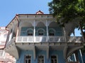 Beautifully restored blue heritage building with wooden ornamental balcony in Sololaki quarter, Tbilisi, Georgia.