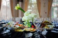 Beautifully set banquet table. Snacks, flowers and wine glasses.