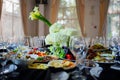 Beautifully set banquet table. Snacks, flowers and wine glasses.