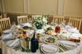 Beautifully set round tables at the restaurant. Delicious food at the wedding reception. White tablecloths and flowers decorations Royalty Free Stock Photo