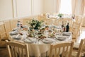 Beautifully set round tables at the restaurant. Delicious food at the wedding reception. White tablecloths and flowers decorations Royalty Free Stock Photo