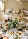 Beautifully set round tables at the restaurant. Delicious food at the wedding reception. White tablecloths and flowers decorations Royalty Free Stock Photo