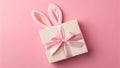 A beautifully wrapped gift box with pink bunny ears on a pastel pink background for Easter Royalty Free Stock Photo