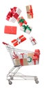 Beautifully wrapped gift boxes falling into metal shopping cart on white background Royalty Free Stock Photo