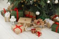 Beautifully wrapped gift boxes, wooden sleigh and lantern under Christmas tree indoors