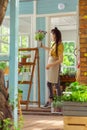 Florist putting flower pot on top of a shelve stand.