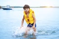 Beautifyl cute little kid boy in the yellow life jacket on a beach lifestyle picture