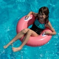 Beautigul smiling girl sitting in the big pink swim tube in the Royalty Free Stock Photo