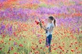 Beautiul caucasian girl holding big bouquet with poppies