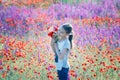 Beautiul girl holding big bouquet with poppies