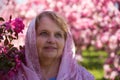 Beauty adult woman wearing beads under pink flowers Royalty Free Stock Photo