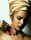 Beauty african woman in shawl on head, very elegant look with gold jewelry close up mulatto makeup