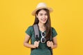 Beauty asian teenager in green tee shirt is backpack traveller isolated on yellow background.