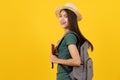 Beauty asian teenager in green tee shirt is backpack traveller isolated on yellow background in studio