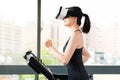 Beauty asian woman running treadmill by VR headset glasses Royalty Free Stock Photo