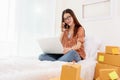 Beauty Asian woman using laptop and calling phone on bed. Business and Technology concept. Delivery and Online shopping concept. Royalty Free Stock Photo