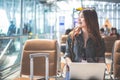 Beauty Asian woman using laptop and looking outside at airport Royalty Free Stock Photo