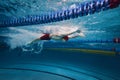Beauty of athleticism in action. Dynamic image of young man, athlete in motion, swimming in s pool indoors, training Royalty Free Stock Photo