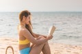 Beauty Attractive Asian woman wearing bikini reading book on the beach Royalty Free Stock Photo