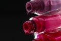 Beauty background saver nail polish is poured out of cans of vials of purple red burgundy pink close-up view from the side Royalty Free Stock Photo