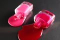 Beauty background two bottles of nail polish bottles red or burgundy pink spill poured on the table on a black background close-up Royalty Free Stock Photo