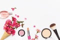 Beauty background. Waffle cone with pink spring flowers and different makeup cosmetic on light background. Face powder lipstick Royalty Free Stock Photo