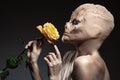 Beauty and the beast. Ugly witch with beautiful flower in hand. Royalty Free Stock Photo