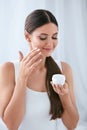 Beauty. Beautiful Woman Applying Face Cream On Soft Facial Skin Royalty Free Stock Photo