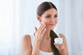 Beauty. Beautiful Woman Applying Face Cream On Soft Facial Skin Royalty Free Stock Photo