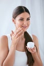 Beauty. Beautiful Woman Applying Face Cream On Soft Facial Skin Royalty Free Stock Photo