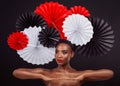 Beauty is beauty, whatever your background. Studio shot of a beautiful young woman posing with a origami fans against a