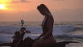 Beauty in black bikini riding the autobike in pose, evening sun is coloured the sky in red,