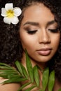 Beauty black skin woman fashion african ethnic female face portrait. Young girl model with afro and tropical leaves in hands