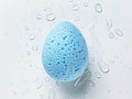 Beauty blender on a white background with water drops.