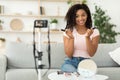 African American Female Beauty Blogger Reviewing Cosmetics Sitting At Home
