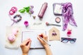 Beauty blog concept. Lilac colour. Female hands writing in notebook among styled accessories: sunglasses, bijouterie, cosmetics an Royalty Free Stock Photo