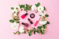 Beauty blogger desk with cosmetics, lipstick, eye shadows, nail polish and pink frame of flowers on pink background. Flat lay, top Royalty Free Stock Photo