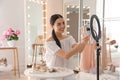 Beauty blogger preparing for video recording in room at home. Using ring lamp and smartphone Royalty Free Stock Photo