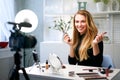 Beauty blogger woman filming daily make-up routine tutorial near camera on tripod. Influencer blonde girl live streaming Royalty Free Stock Photo