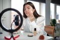 beauty blogging, technology and people concept portrait of a happy smiling girl blogger with ring light and smartphone applying