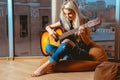 Beauty blonde woman trying to play guitar