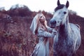 beauty blondie with horse in the field, effect of toning Royalty Free Stock Photo