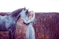 beauty blondie with horse in the field, effect of toning Royalty Free Stock Photo