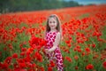 Beauty blue eyes teen enjoy summer days .Cute fancy dressed girl in poppy field. Field of blooming poppies Royalty Free Stock Photo