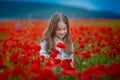 Beauty blue eyes teen enjoy summer days .Cute fancy dressed girl in poppy field. Field of blooming poppies Royalty Free Stock Photo