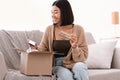 Happy asian lady unpacking parcel with beauty box Royalty Free Stock Photo