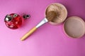 Beauty box, powder with a brown brush from nap for makeup, pink perfume and earrings on a background. Flat lay. Top view Royalty Free Stock Photo