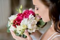 Beauty bride in bridal gown with bouquet and lace veil indoors Royalty Free Stock Photo