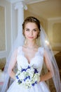 Beauty bride in bridal gown with bouquet and lace veil indoors Royalty Free Stock Photo