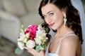 Beauty bride in bridal gown with bouquet and lace veil indoors Royalty Free Stock Photo